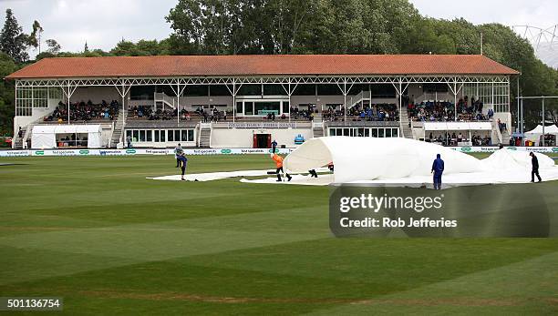 Ground staff put covers on due to rain during day four of the First Test match between New Zealand and Sri Lanka at University Oval on December 13,...