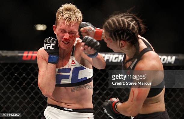 Jocelyn Jones-Lybarger takes a punch from Tecia Torres in a strawweight fight during UFC 194 on December 12, 2015 in Las Vegas, Nevada.