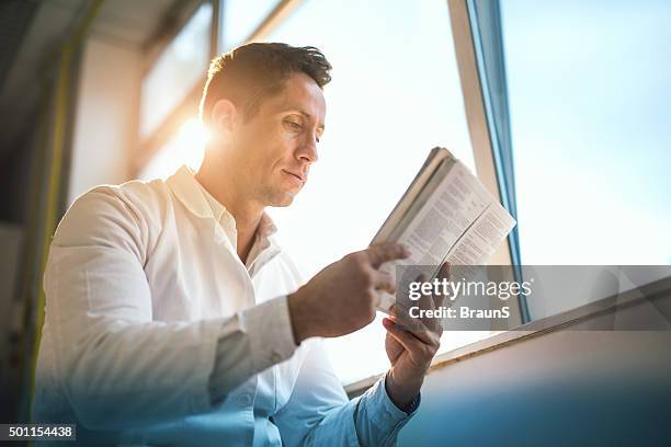 below view of a male doctor reading medical data. - doctor publication stock pictures, royalty-free photos & images