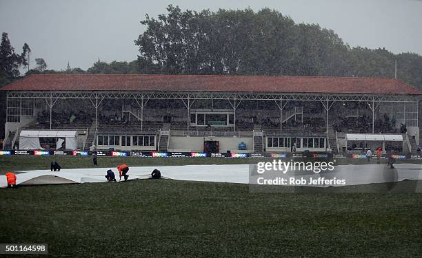 Ground staff lay covers as a wet and wild storm front hits the University Ovel, Dunedin during day four of the First Test match between New Zealand...