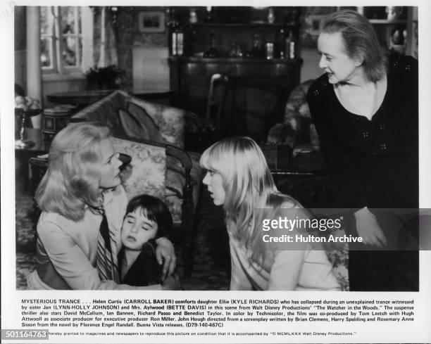 Carroll Baker holds Kyle Richards as Lynn-Holly Johnson and Bette Davis look scared in a scene for the Walt Disney movie "The Watcher in the Woods"...