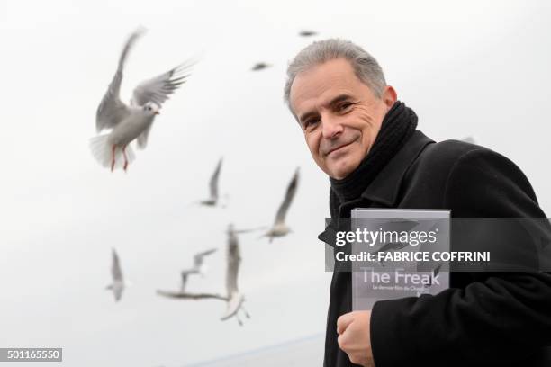 Swiss author Pierre Smolik poses with his book "The Freak, the last film of Chaplin" on December 7, 2015 where English comic actor and filmmaker...