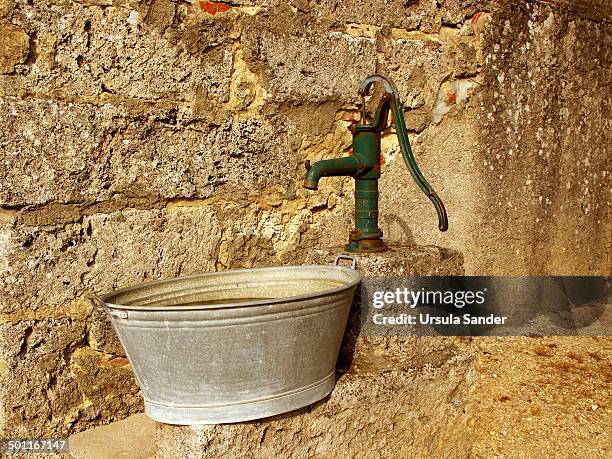 historic waterpump and bathtub of zinc - washing tub stockfoto's en -beelden