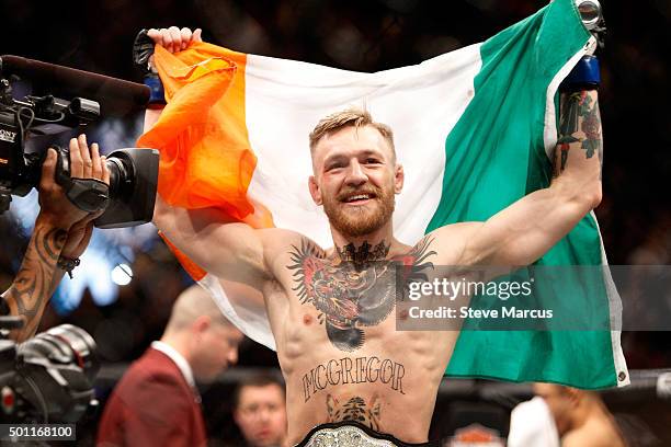 Conor McGregor celebrates after a first-round knockout victory over Jose Aldo in their featherweight title fight during UFC 194 on December 12, 2015...