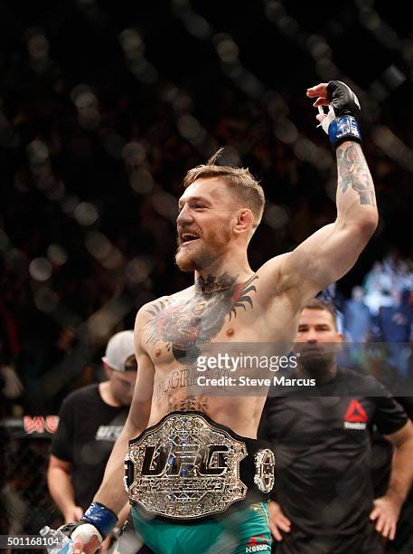 Conor McGregor celebrates after a first-round knockout victory over Jose Aldo in their featherweight title fight during UFC 194 on December 12, 2015...
