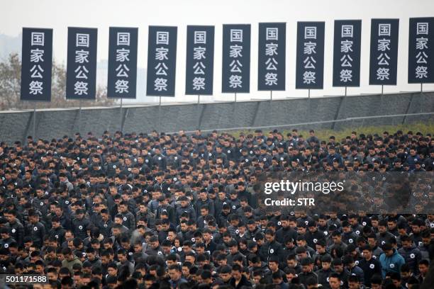 People stand for a moment of silence as they gather in front of the Nanjing Massacre Memorial Hall on the second annual national day of remembrance...