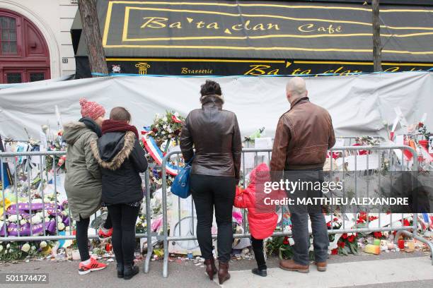 People pay tribute to victims in front of the music hall Bataclan in Parin on December 13 a month after the Paris terror attacks on November 13, 2015...