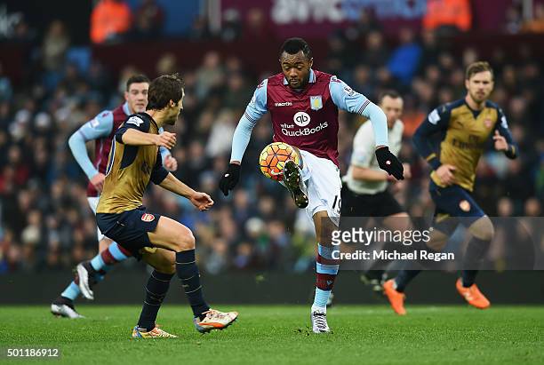 Jordan Ayew of Aston Villa controls the ball under pressure from Mathieu Flamini of Arsenal during the Barclays Premier League match between Aston...
