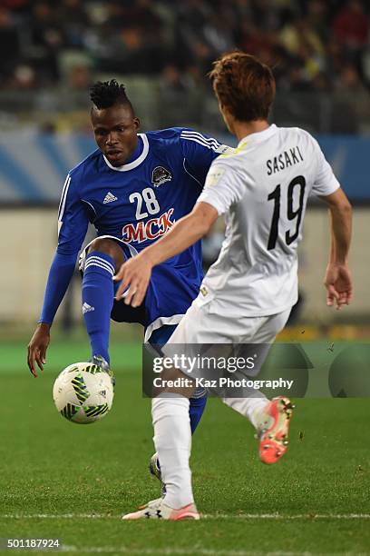Thomas Ulimwengu of TP Mazembe shoots the ball under the challenge from Sho Sasaki of Sanfrecce Hiroshima at Osaka Nagai Stadium on December 13, 2015...