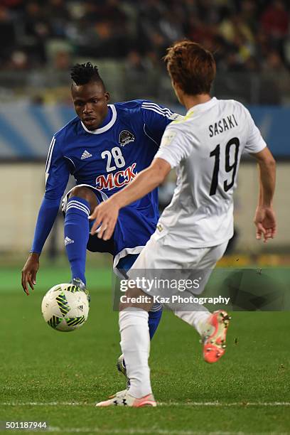 Thomas Ulimwengu of TP Mazembe shoots the ball under the challenge from Sho Sasaki of Sanfrecce Hiroshima at Osaka Nagai Stadium on December 13, 2015...