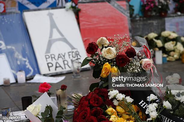 Candles and flowers are placed at a makeshift memorial in Place de la Republique square in Paris on December 13 a month after the Paris terror...