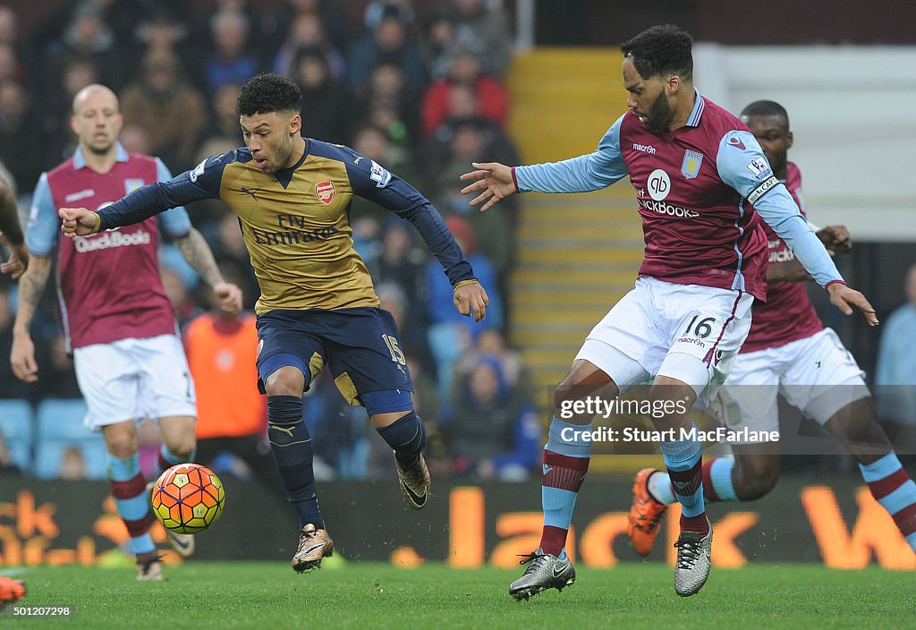 Alex Oxlade-Chamberlain of Arsenal takes on Joleon Lescott of Aston