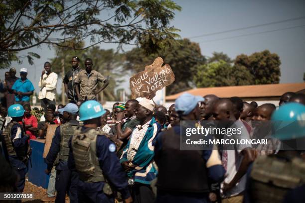 Residents of the PK5 district hold a banner reading "We want to vote" as they demonstrate in front of the MINUSCA, the United Nations mission in...