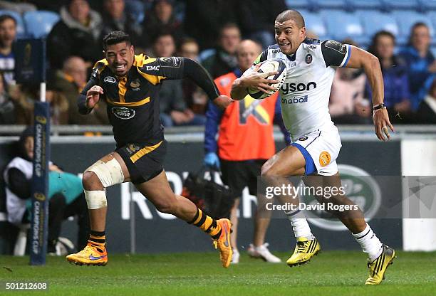 Jonathan Joseph of Bath breaks away from Charles Piutau for the first try during the European Rugby Champions Cup match between Wasps and Bath at the...