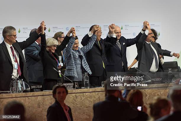 Foreign Affairs Minister and President-designate of COP21 Laurent Fabius , raises hands with Secretary General of the United Nations Ban Ki Moon and...