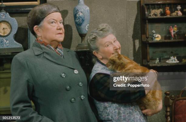 From right to left - English actresses Margot Bryant as 'Minnie Caldwell' holding a pet cat and Violet Carson as 'Ena Sharples' pictured together in...