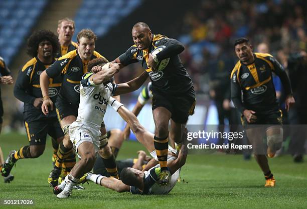 Sailosi Tagicakibau of Wasps is tackled by Kyle Eastmond during the European Rugby Champions Cup match between Wasps and Bath at the Ricoh Arena on...