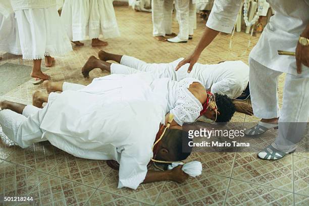 Worshippers lie on the floor during a Candomble ceremony honoring goddesses Iemanja and Oxum on December 12, 2015 in Itaborai, Brazil. Candomble is...