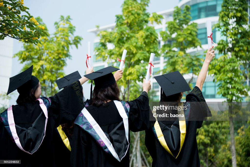 Four female graduates at campus