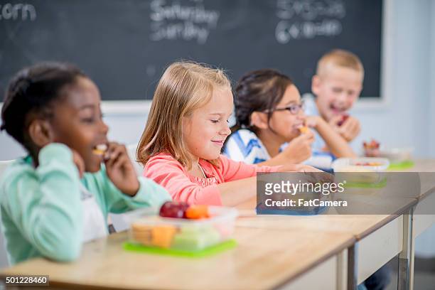 students eating snacks at school - lunch stockfoto's en -beelden