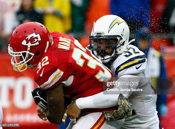 Running back Spencer Ware of the Kansas City Chiefs carries the ball as free safety Eric Weddle of the San Diego Chargers tackles during the game at...