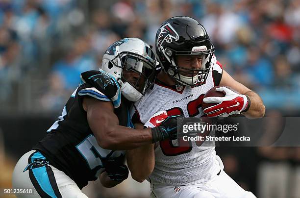 Bene' Benwikere of the Carolina Panthers tackles Jacob Tamme of the Atlanta Falcons during their game at Bank of America Stadium on December 13, 2015...