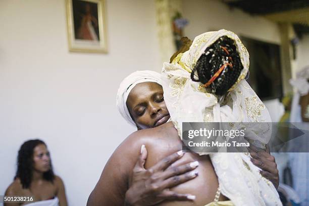 Worshippers hug during a Candomble ceremony honoring goddesses Iemanja and Oxum on December 13, 2015 in Itaborai, Brazil. Candomble is an...