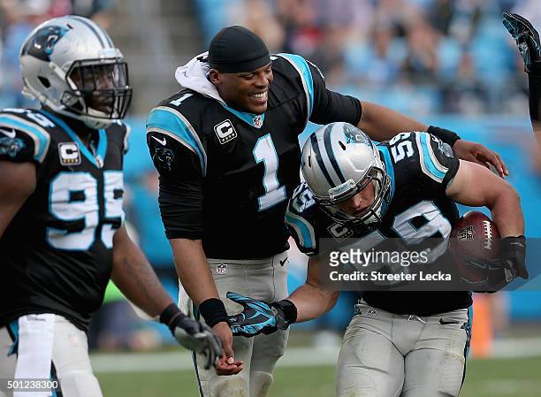 Cam Newton congratulates teammate Luke Kuechly of the Carolina Panthers after Kuechly made an interception in the third quarter during their game...