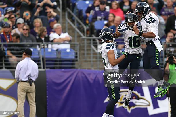 Wide receiver Tyler Lockett of the Seattle Seahawks celebrates with teammates wide receiver Doug Baldwin and quarterback Russell Wilson after scoring...