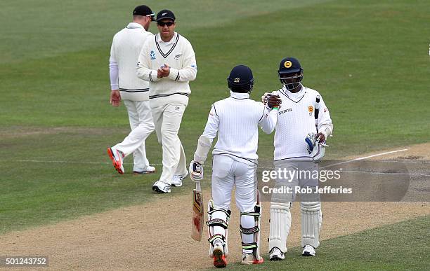 Dinesh Chandimal of Sri Lanka is congratulated by his captain Angelo Mathews on scoring 50 runs during day five of the First Test match between New...