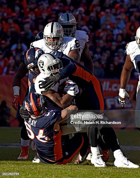 Denver Broncos linebacker Shane Ray and Denver Broncos nose tackle Sylvester Williams put a stop on Oakland Raiders running back Latavius Murray...