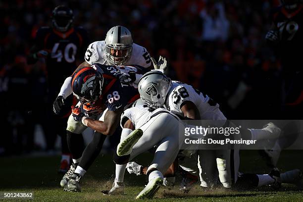 Wide receiver Demaryius Thomas of the Denver Broncos is hit by strong safety T.J. Carrie, outside linebacker Malcolm Smith, and cornerback David...