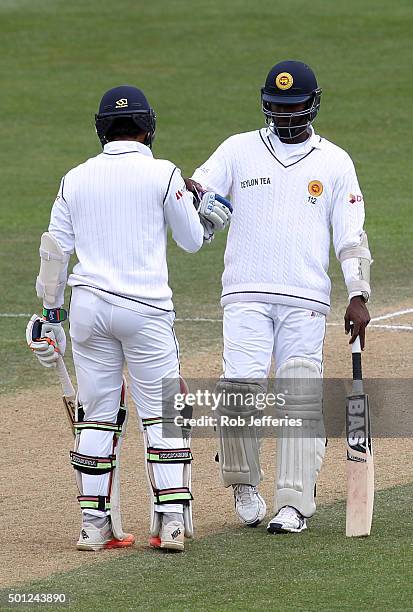 Angelo Mathews of Sri Lanka congratulates Dinesh Chandimal on scoring 50 runs during day five of the First Test match between New Zealand and Sri...