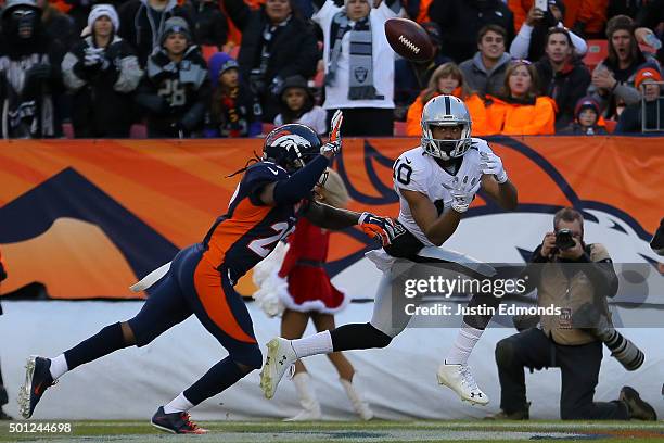 Wide receiver Seth Roberts of the Oakland Raiders makes a catch for a third quarter touchdown against the Denver Broncos under coverage by free...