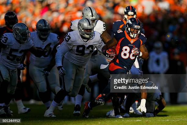 Wide receiver Demaryius Thomas of the Denver Broncos rushes for yards after a catch of a tipped ball and is pursued by defensive tackle Leon Orr of...
