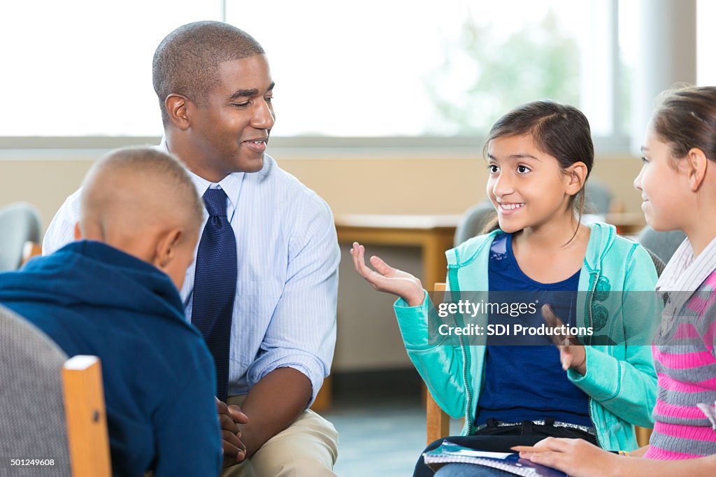 Elementary age kids talking to counselor during group therapy session