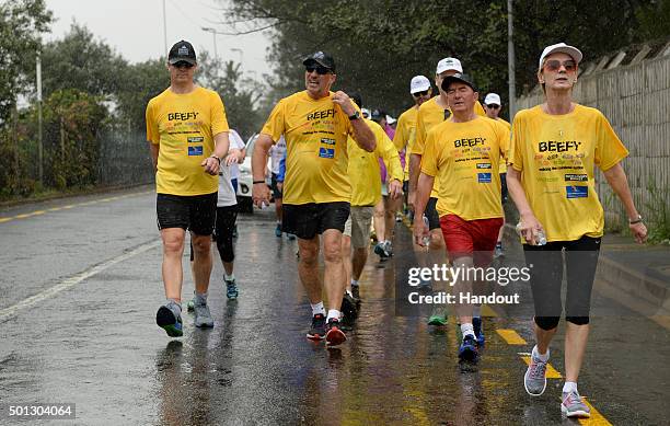 In this handout image provided by Philip Brown, Sir Ian Botham and his supporters walk the 'Beefy Walking the Rainbow Nation' charity walk across...