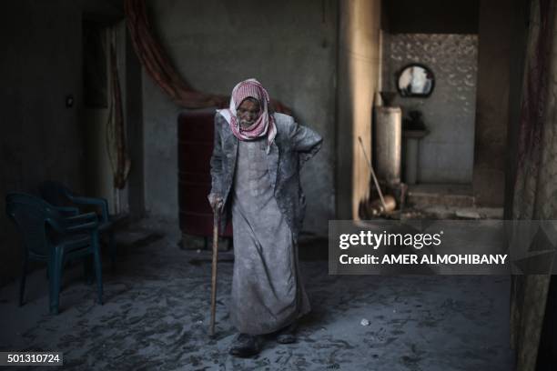 Syrian Abu Mohammed, covered with dust from explosions, walks in his home following reported air strikes by regime forces on the town of...