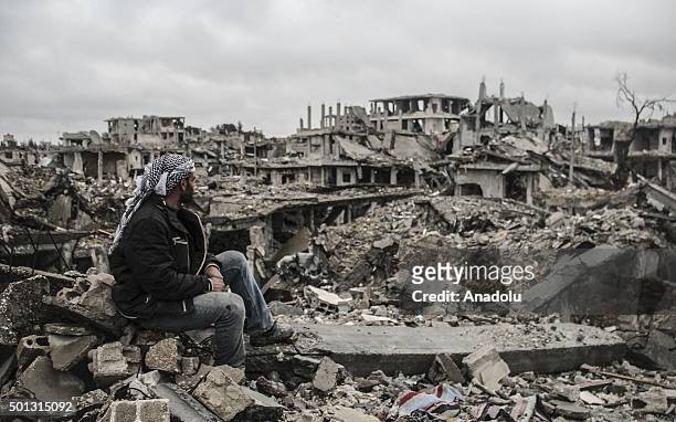 Man looks at the rubble of buildings destroyed in the clashes between DAESH militants and Kurdish armed armed groups in the center of the Syrian town...
