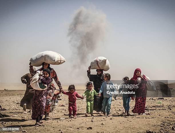 Escape from the bombs: Smoke rises from Rasulayn region of Al-Hasakah as Syrians cross into Turkey from the borderline in Akcakale district of...