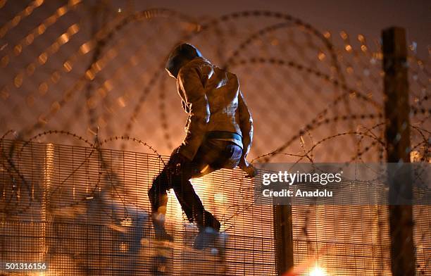 Migrants camped out in Calais, attempts to climb a security fence near refugee camp of Calais, France on August 3, 2015. More than 2 thousands...