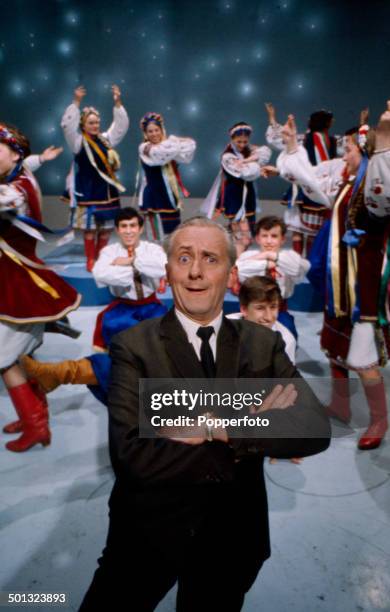 English television presenter Hughie Green posed on the set of the television talent show 'Opportunity Knocks' in 1965.