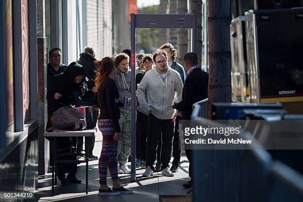 People go through security screening to walk down the sidewalk on Hollywood Boulevard between Highland and La Brea avenues before the start of the...
