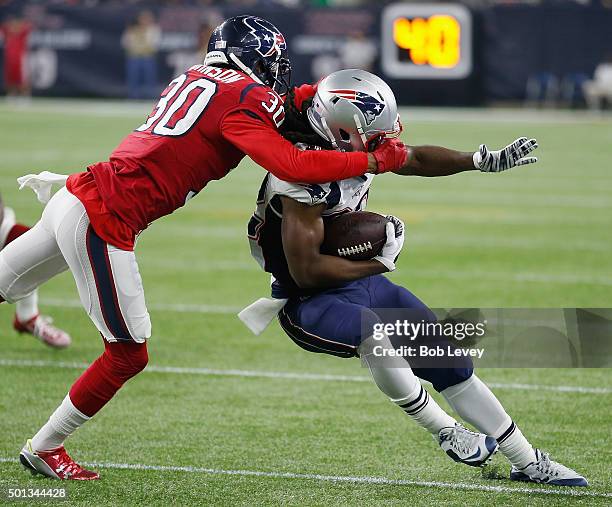 Keshawn Martin of the New England Patriots breaks a tackle attempt by Kevin Johnson of the Houston Texans at NRG Stadium on December 13, 2015 in...