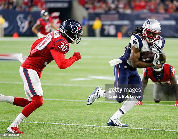 Keshawn Martin of the New England Patriots breaks a tackle attempt by Kevin Johnson of the Houston Texans at NRG Stadium on December 13, 2015 in...