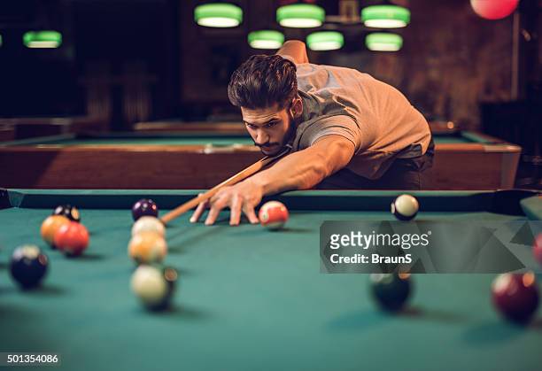 hombre apuntando en concentrado mientras juegan al billar bola de billar. - pool table fotografías e imágenes de stock