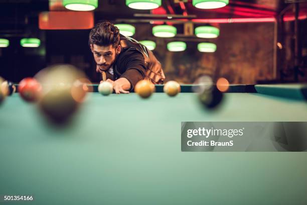 young man aiming at ball during a pool game. - billiard ball game stockfoto's en -beelden