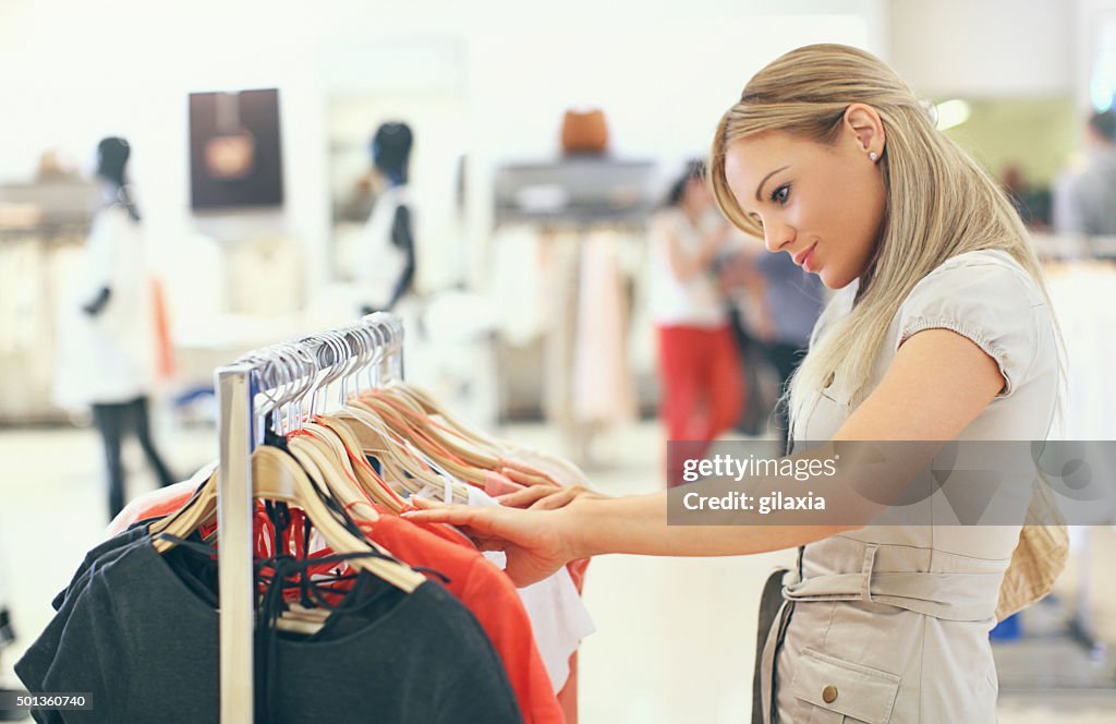 Woman buying clothes at department store.
