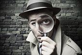 Vintage detective looking through a magnifier