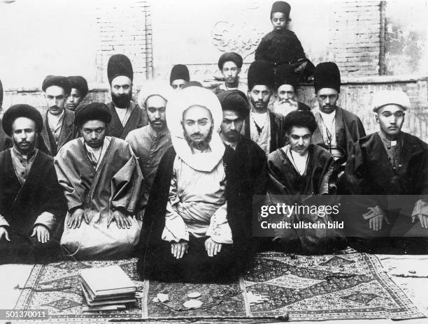 Iran , Shiite cleric praying together with his relatives and servants. - probably in the 1910s